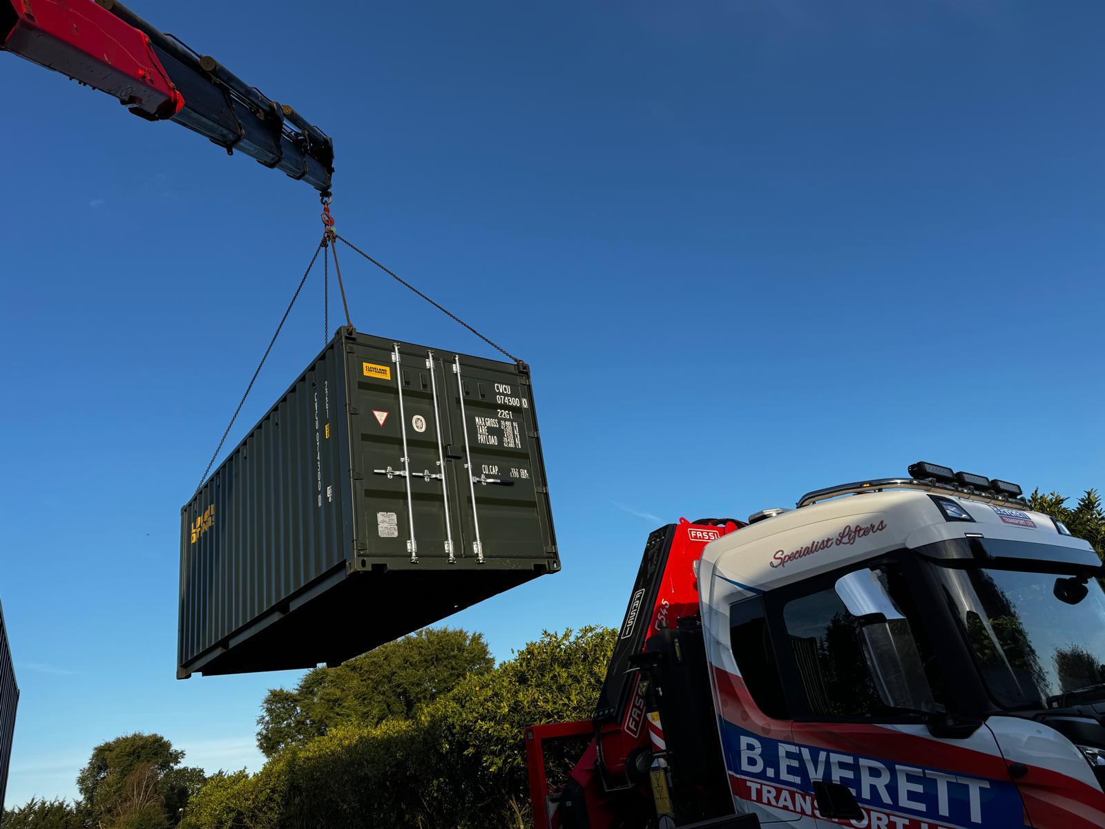 Crane lifting shipping container into position